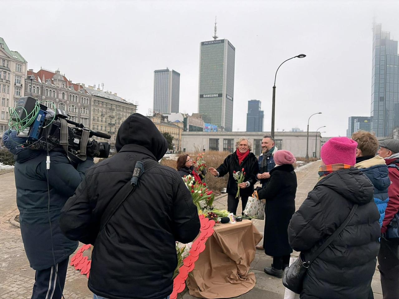 Doktor Artur Zagajewski rozdaje kwiaty w centrum Warszawy | fot. Bartosz Pańczyk
